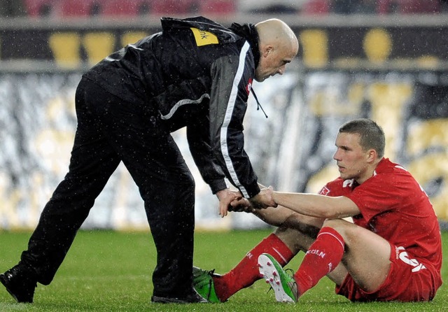 Am Boden: Lukas Podolski (rechts) ben... Gladbacher Trainer Michael Frontzeck.  | Foto: dpa