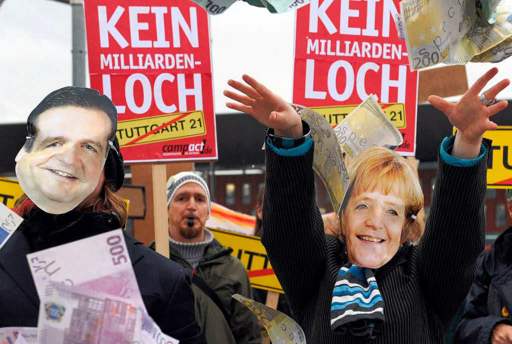 Mit Merkel- und Mappus-Masken verkleidete Stuttgart 21 Gegner protestieren  in Karlsruhe