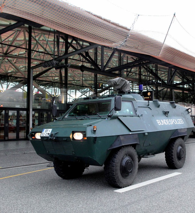 Ein gepanzertes Fahrzeug der Bundespol...al 1 des Hamburger Flughafens vorbei.   | Foto: dpa