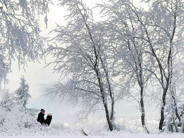 Ein Paar steht im verschneiten Wald auf dem Kahlen Asten  im Hochsauerland.   | Foto: dpa