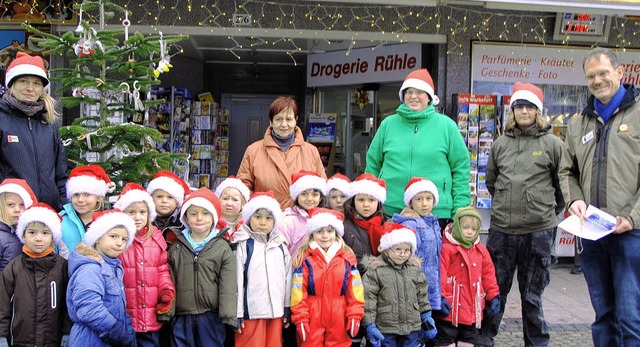 Kinder schmcken Weihnachtsbume &#821...gerie-Inhaber Jrgen Rhle (rechts).    | Foto: Sedlak