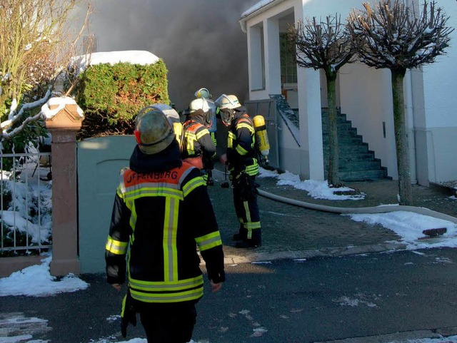 Feuerwehrleute vor dem brennenden Haus in Offenburg. 