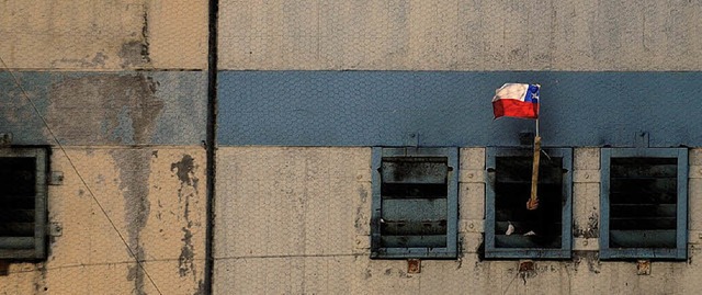 Eine Gefangener ruft mit chilenischer Flagge um Hilfe.  | Foto: afp
