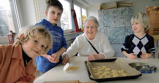 In der DRK-Weihnachtsbckerei: Grundschler mit Seniorin   | Foto: DRK