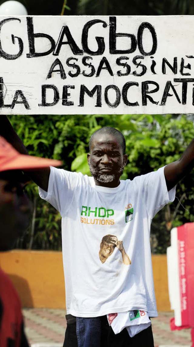 Fr diesen Demonstranten in Abidjan is...rent Gbagbo ein Mrder der Demokratie.  | Foto: afp