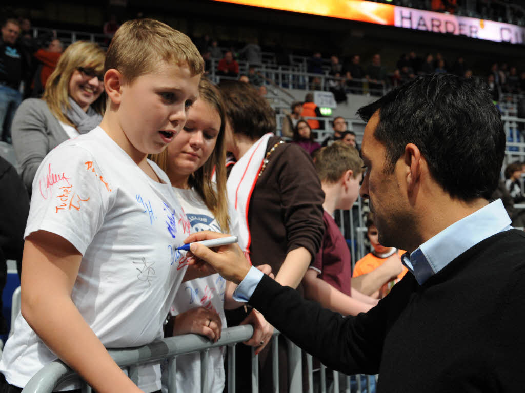 Trainer Robin Dutt gibt einem jungen Fan ein Autogramm.