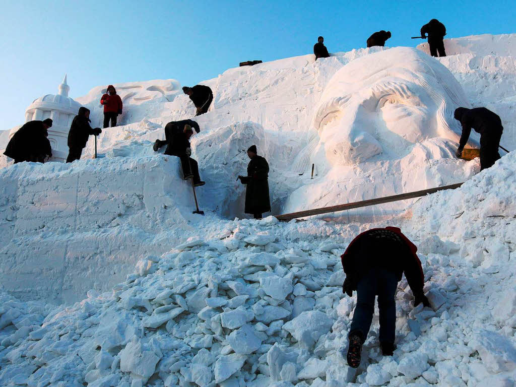 Viele fleiige Hnde sind am Entstehen eines Schneekopfes beteiligt.