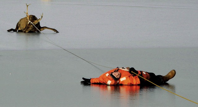 Mit einem Seil werden im nordrhein-wes...che gerettet, die eingebrochen waren.   | Foto: dpa