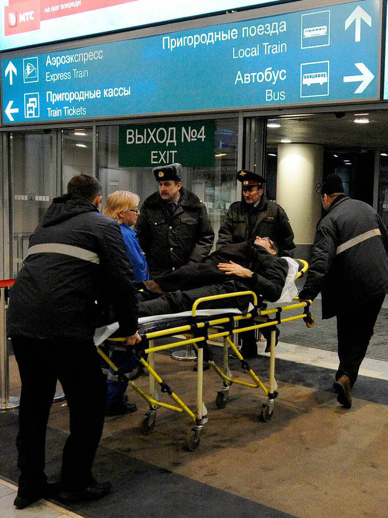 Sanitter schieben im Flughafen Domodedowo in Moskau einen Verletzten auf einer Trage.