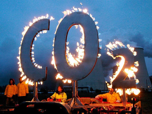 Mit einem brennenden &quot;CO 2-Zeiche...ce Mitglieder vor einem Atomkraftwerk.  | Foto: dpa