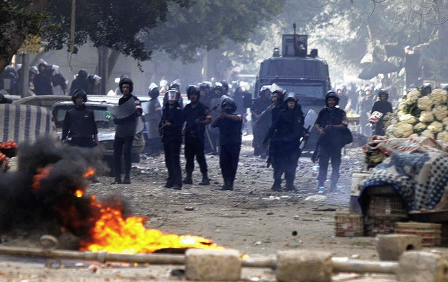 gyptische Polizisten stellen sich den...n in einer Strae von Kairo entgegen.   | Foto: AFP
