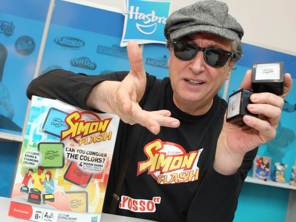 Der ehemalige TV-Zauberer Salvatore posiert mit zwei Spielsteinen des Spiels "Simon Flash"