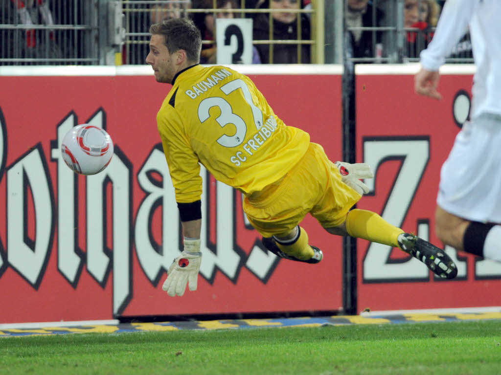Torwart Oliver Baumann von Freiburg wehrt einen Ball ab.
