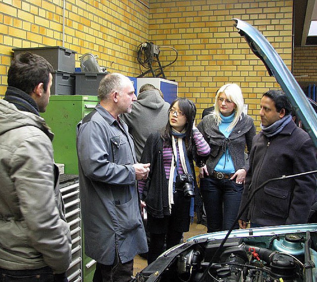 GHSE-Lehrer Michael Fu zeigt den Gsten die Kfz-Werkstatt.  | Foto: schule