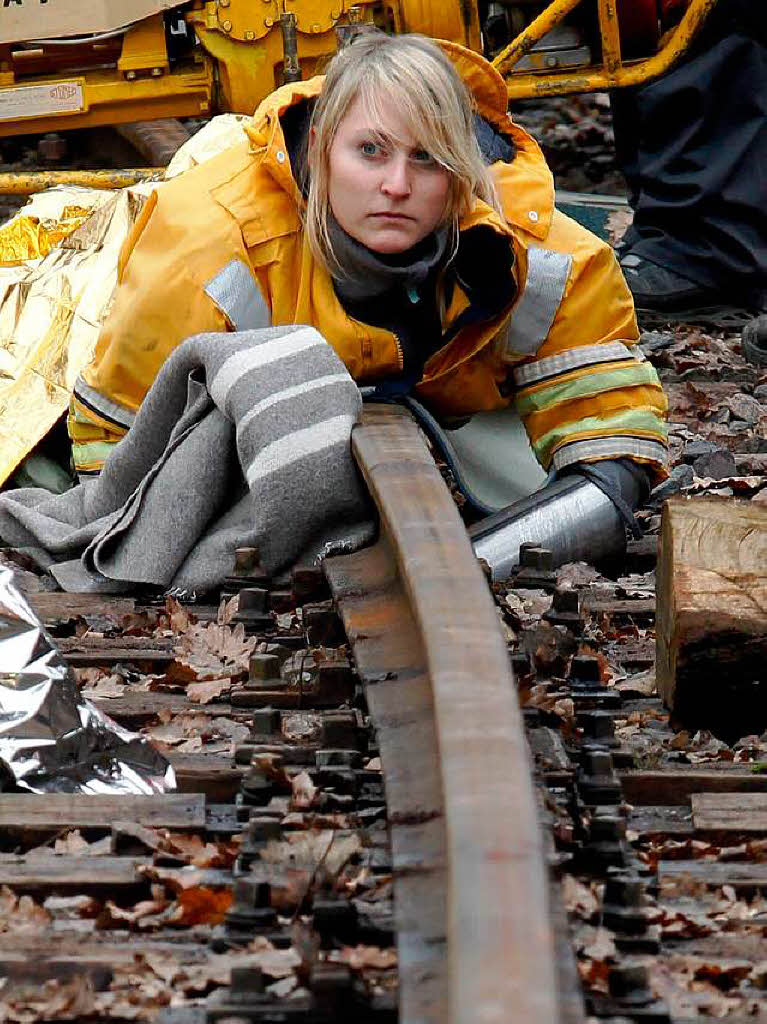 Eine Aktivistin, die sich mit ihren Hnden an ein Gleis kettete, liegt auf einem Gleis zur ehemaligen Wiederaufarbeitungsanlage Karlsruhe.