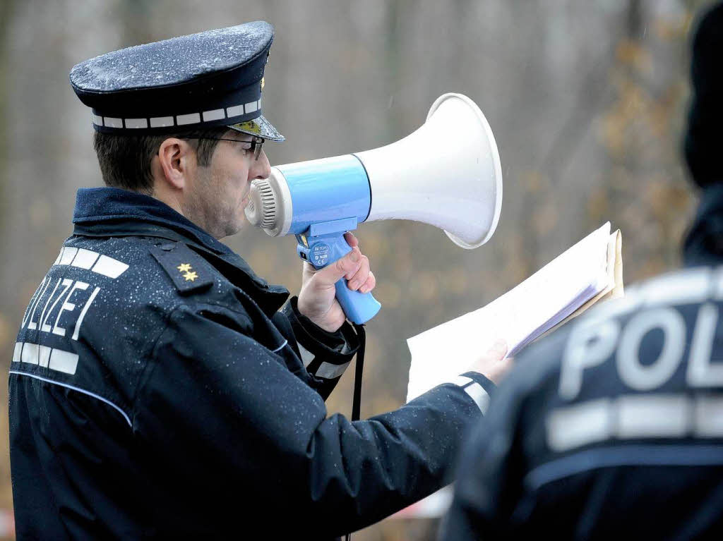 Ein Polizist spricht in Karlsruhe zu den Aktivisten der Umweltschutzorganisation Greenpeace.