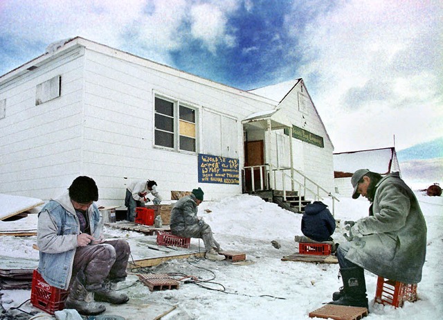 Mnner sitzen vor einem Haus in Iqalui...ele Tuberkuloseerkrankungen gemeldet.   | Foto: AFP