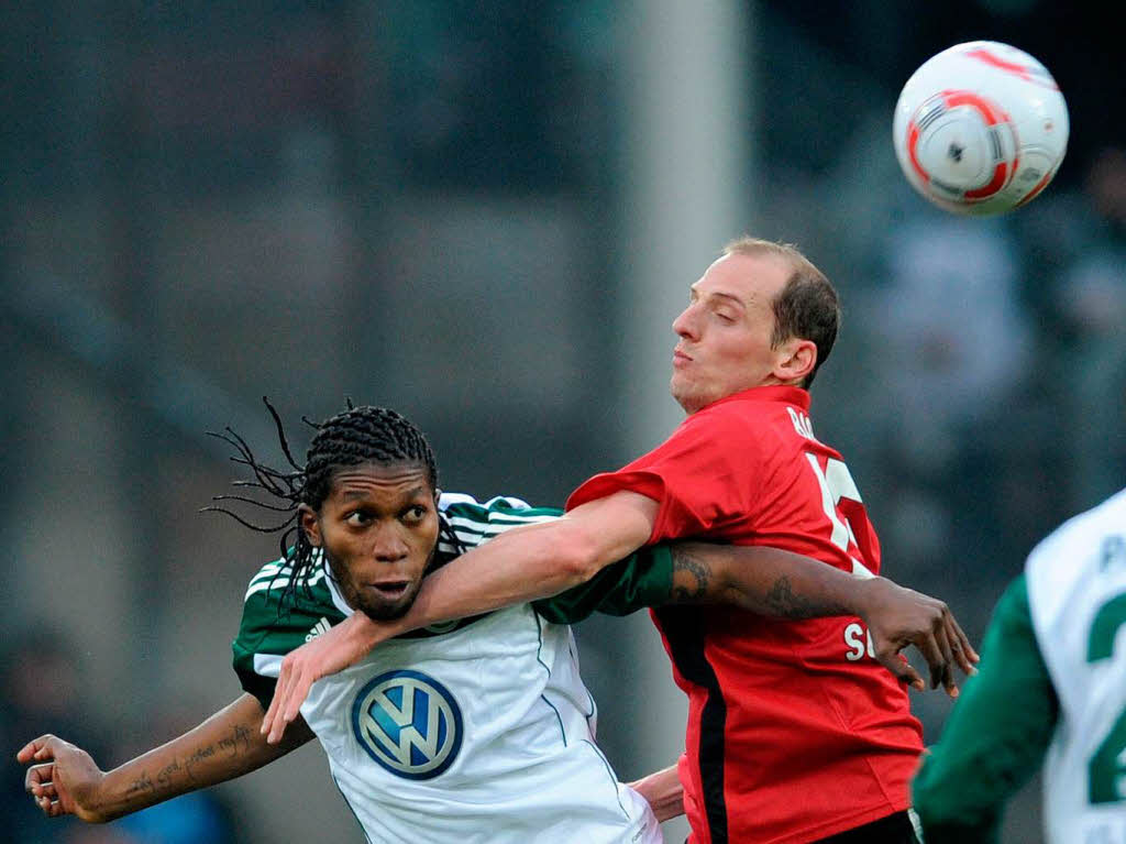 Oliver Barth kmpft mit harten Bandagen gegen Wolfsburgs Joker Dieudonne Mbokani (l.).