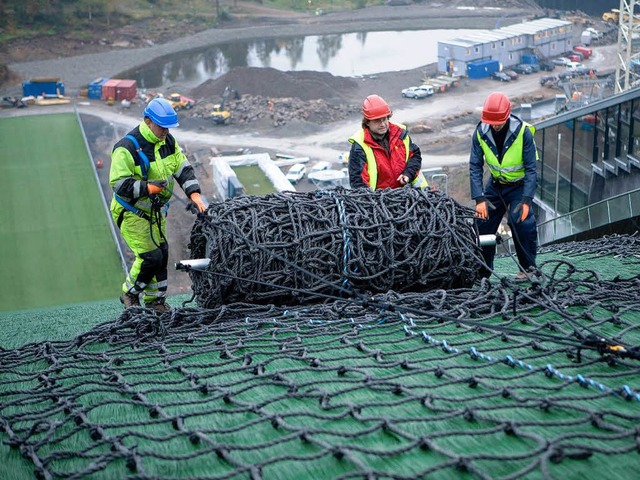 An Seilen gesichert rollen die Mitarbe...Netz auf der Holmenkollen-Schanze aus.  | Foto: Seil-Frey GmbH