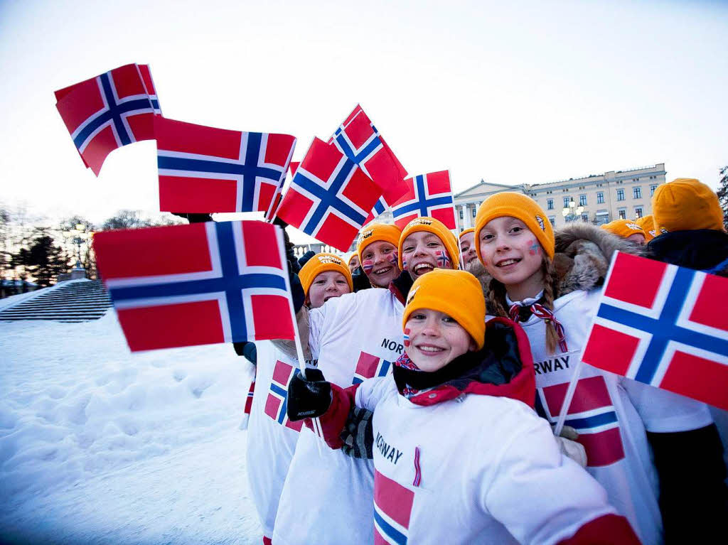 Kinder winken mit der norwegischen Flagge