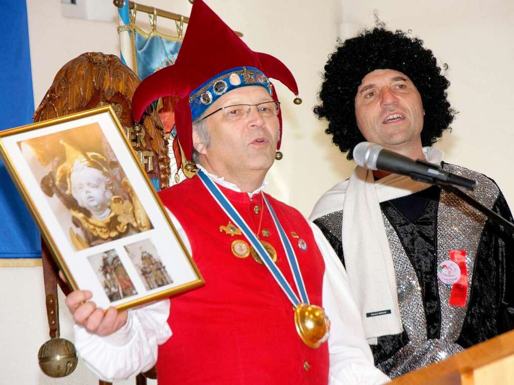 Oberzunftmeister Franz-Josef Vollherbst und Stadtpfarrer Ekkehard Baumgartner mit dem Foto vom Engeli mit Jokilikppli in der Peterskirche.