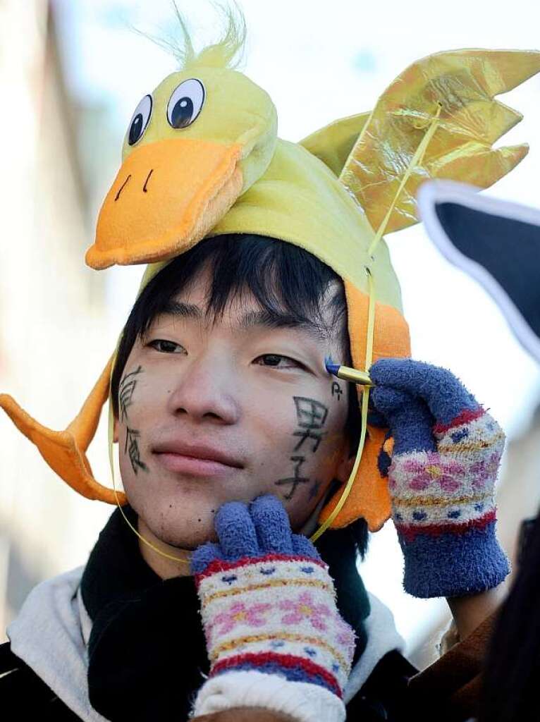 Ein Student aus Japan wird vor dem Dsseldorfer Rosenmontagsumzug noch geschminkt.