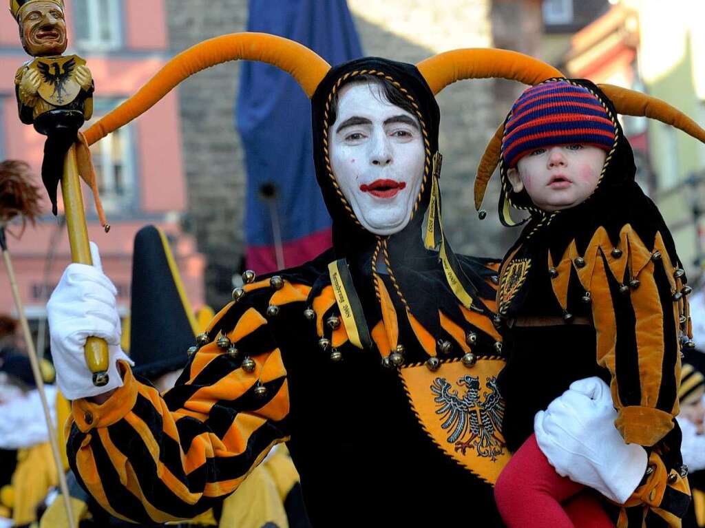 Ein sogenannter Kleidlestrger nimmt mit einem Nachwuchs-Narren an der Parade in Rottweil teil.