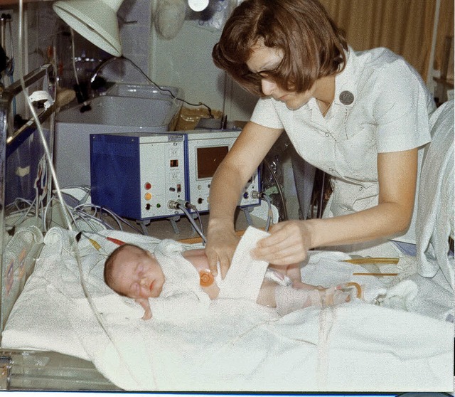 Eine Krankenschwester beim wickeln eines Suglings, 1975   | Foto: Privat