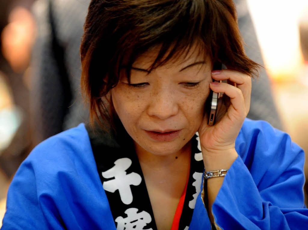 Eine japanische Mitarbeiterin versucht von der Internationalen Tourismusbrse in Berlin nach Japan zu telefonieren.