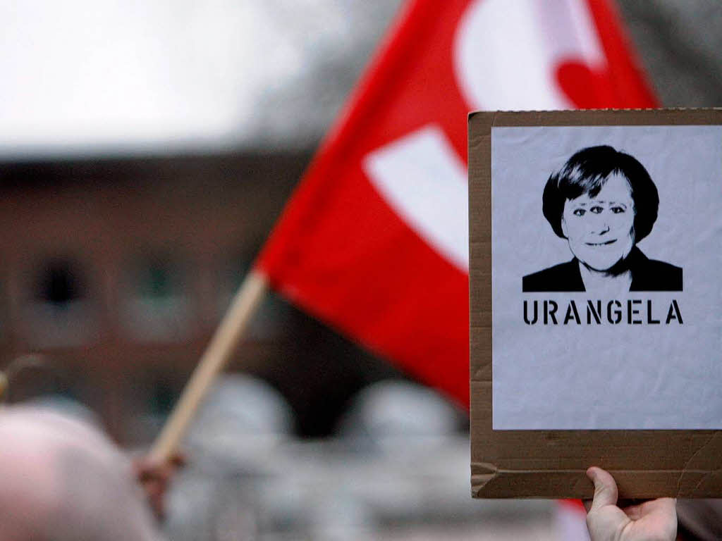 Ein Transparent mit einer dreiäugigen Bundeskanzlerin Angela Merkel und der Aufschrift „Urangela“ in Köln Ein Transparent mit einer dreiäugigen Bundeskanzlerin Angela Merkel und der Aufschrift „Urangela“ in Köln