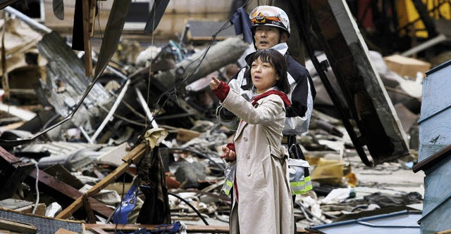 Um sie herum nur Trmmer, aber ans Auf...se Frau und der Rettungshelfer nicht.   | Foto: AFP