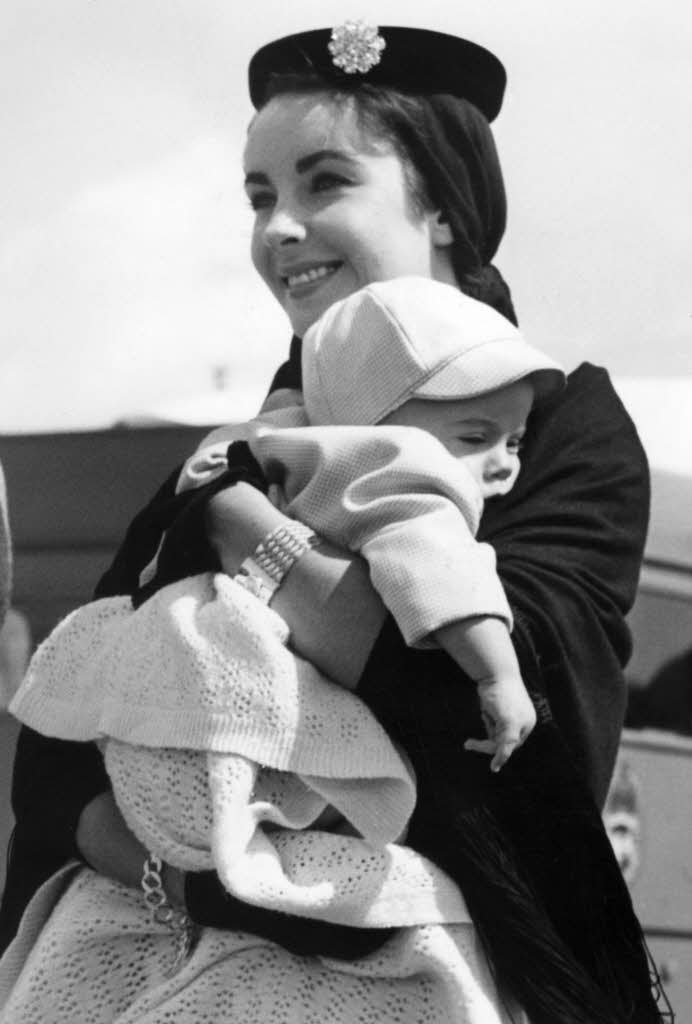 Elizabeth Taylor und ihr sieben Monate alter Sohn Michael Howard Fielding auf dem Londoner Flughafen.