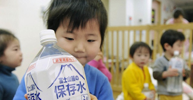 In Tokio wird sauberes Trinkwasser an Kinder verteilt.   | Foto: DPA