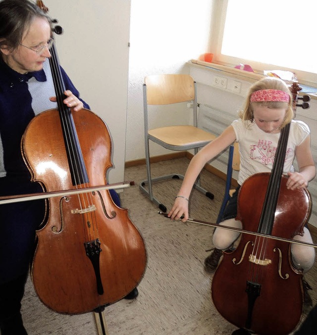 Die ersten Bogenstriche probiert ein M...s, die Cellolehrerin gibt Tipps dazu.   | Foto: joanna sykora