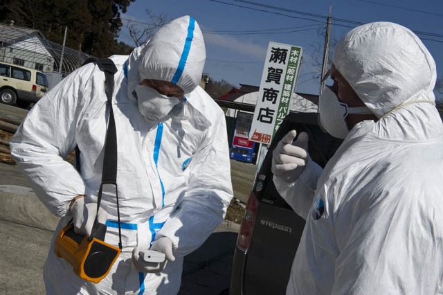 Greenpeace-Mitglieder messen hier 30 K...-AKW Fukushima entfernt die Strahlung.  | Foto: AFP