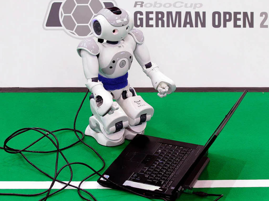 Ein humanoider Standardroboter ist  an einen Laptop angeschlossen.