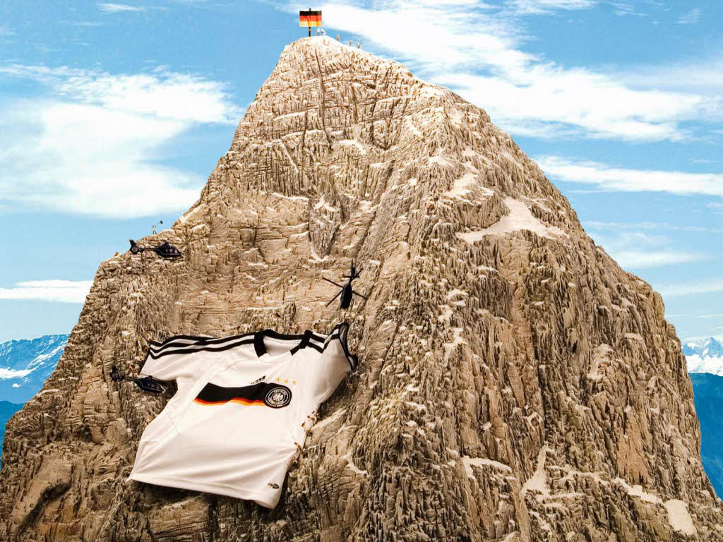 100 deutsche Bergsteiger erklimmen das Matterhorn und breiten ein riesiges Deutschland Trikot aus.