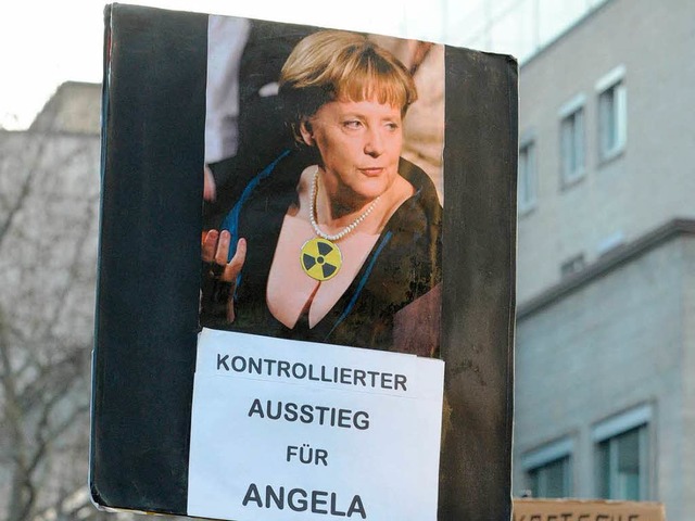 Ein Plakat spielt mit den Themen Merkel und Ausstieg.  | Foto: dpa