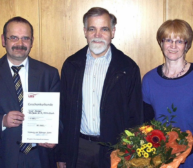 Vorstandsmitglied Erich Greil berreic...nd seiner Ehefrau die Bausparurkunde.   | Foto: ZVg