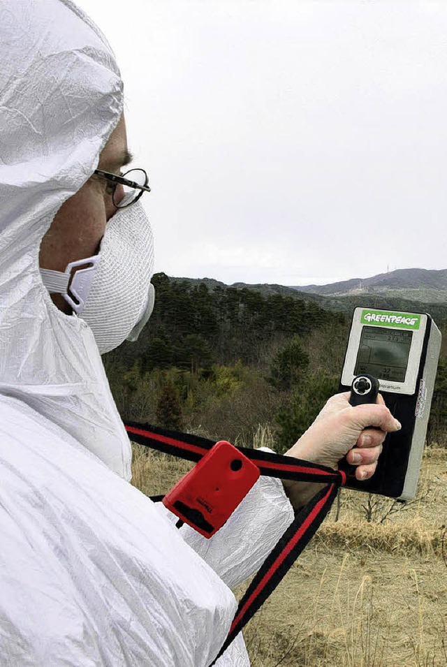 Ein Greenpeace-Aktivist  misst die Strahlung in AKW-Nhe.    | Foto: AFP