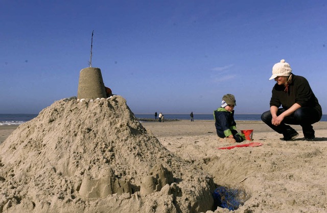 Mami und Max bauen eine Sandburg. An P...e Jacke und keine Ohrenschtzer mehr.   | Foto: dpa