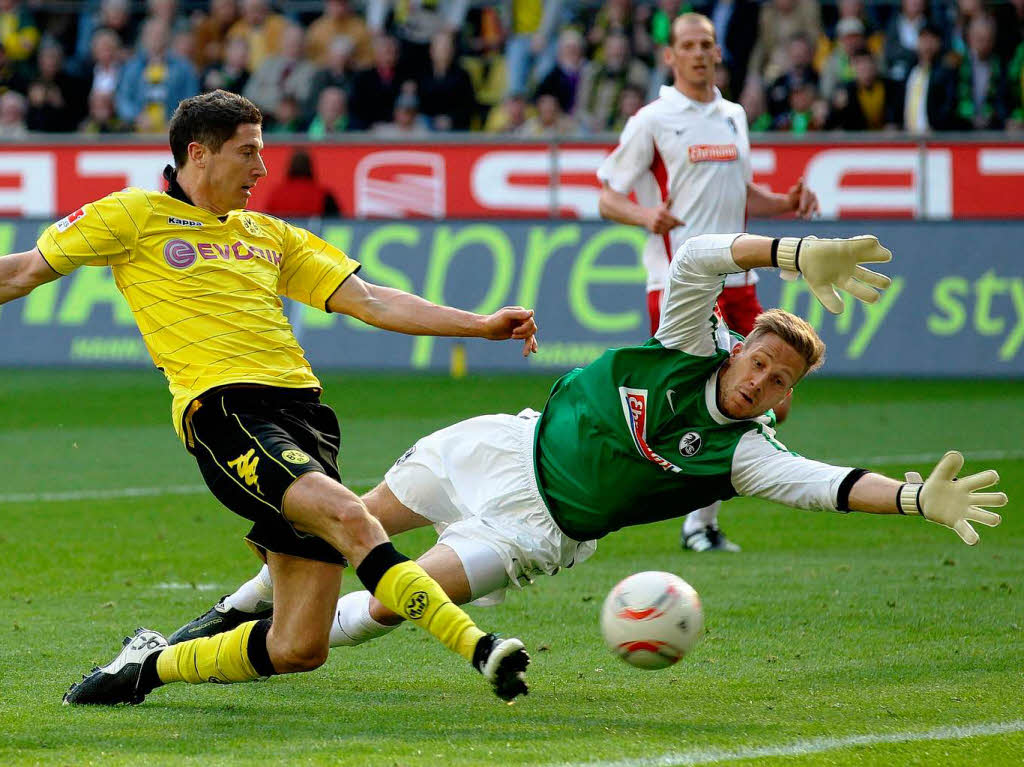 Der Dortmunder Torschtze Robert Lewandowski (Polen) trifft mit diesem Schu zum 2:0 gegen den Freiburger Torwart Oliver Baumann.