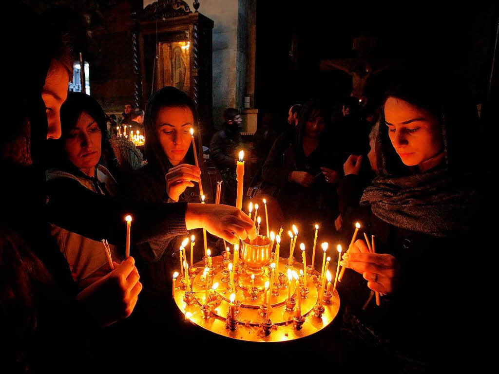 Georgische Glubige znden Kerzen an