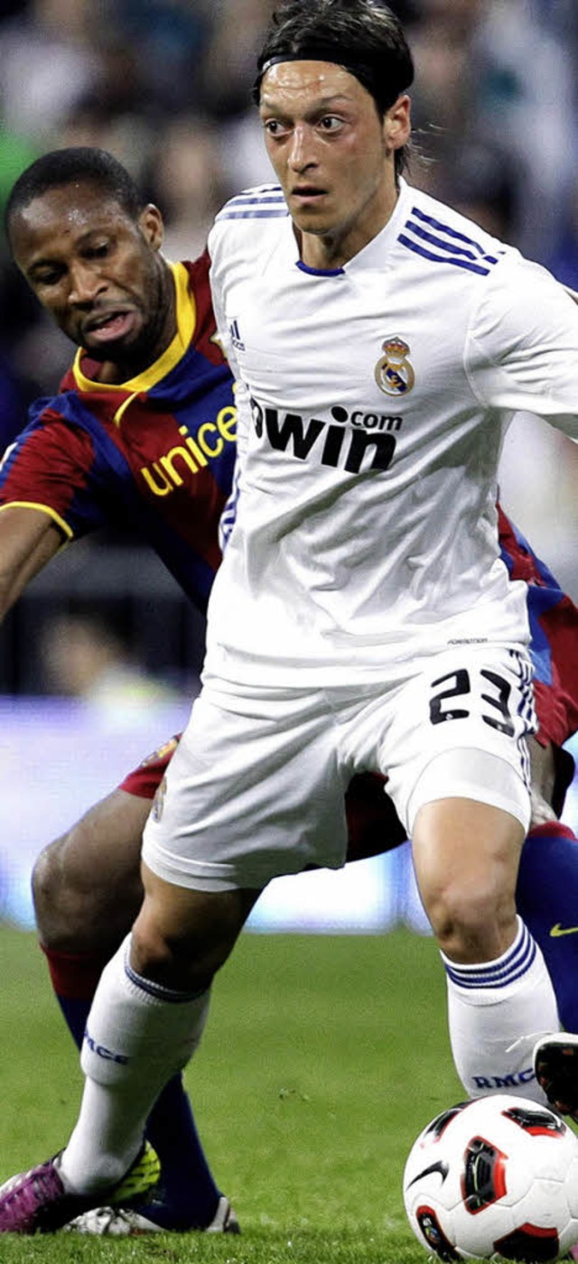 Mesut zil (vorn) im Zweikampf mit Seydou Keita vom Rivalen FC  Barcelona.  | Foto: dpa