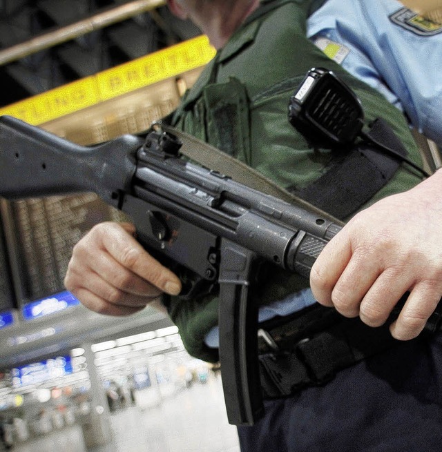 Ein Polizeibeamter mit Maschinenpistol...n Flughfen und Bahnhfen verschrft.   | Foto: dpa