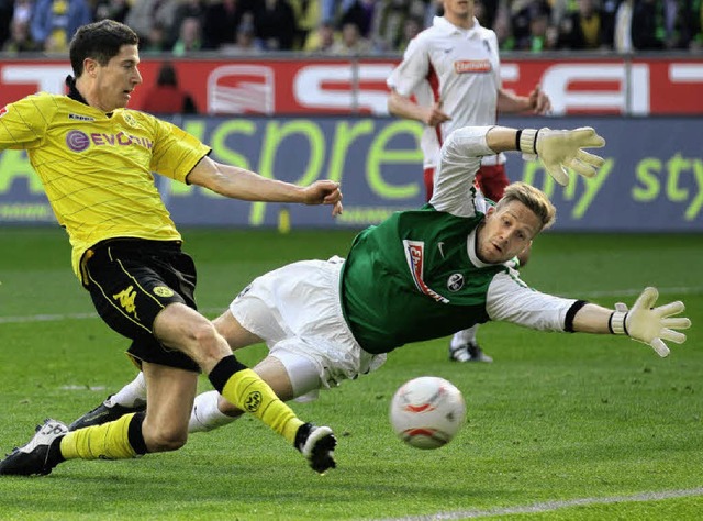SC-Torwart Oliver Baumann in Aktion: H...mit dem Dortmunder Robert Lewandowski.  | Foto: dpa