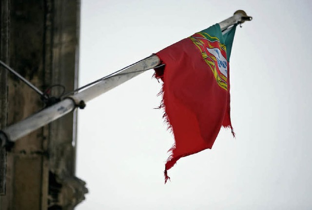 Eine zerfledderte portugiesische Flagg...ast am Finanzministerium in Lissabon.   | Foto: dapd