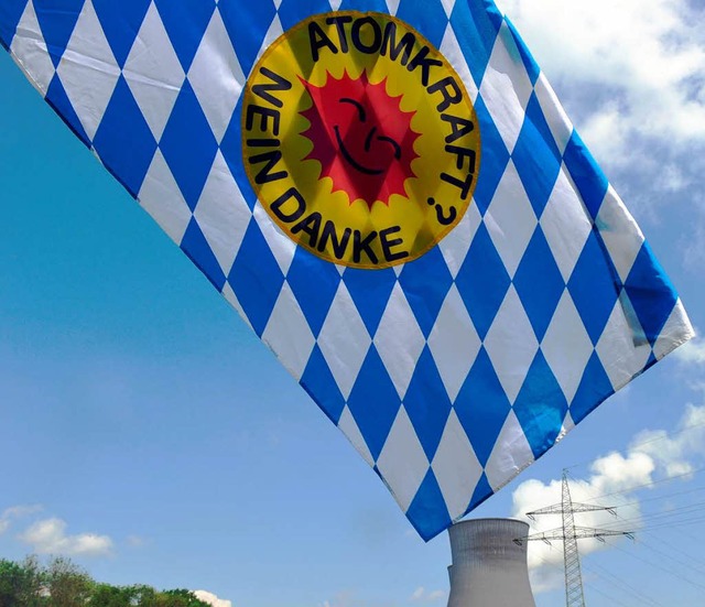 Eine bayerische Flagge mit Anti-Atom-L...eht vor dem AKW Gundremmingen im Wind.  | Foto: dpa
