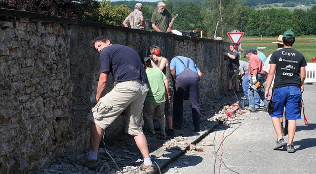 Viele freiwillige Helfer jeden Alters ... von der Friedhofsmauer zu entfernen.   | Foto: Cremer