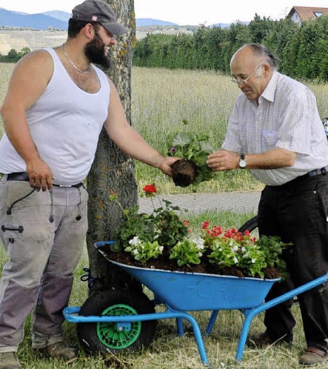 Die freiwilligen Helfer des Heimat- un...r sommerlichen Blumenschmuck im Dorf.  | Foto: alx